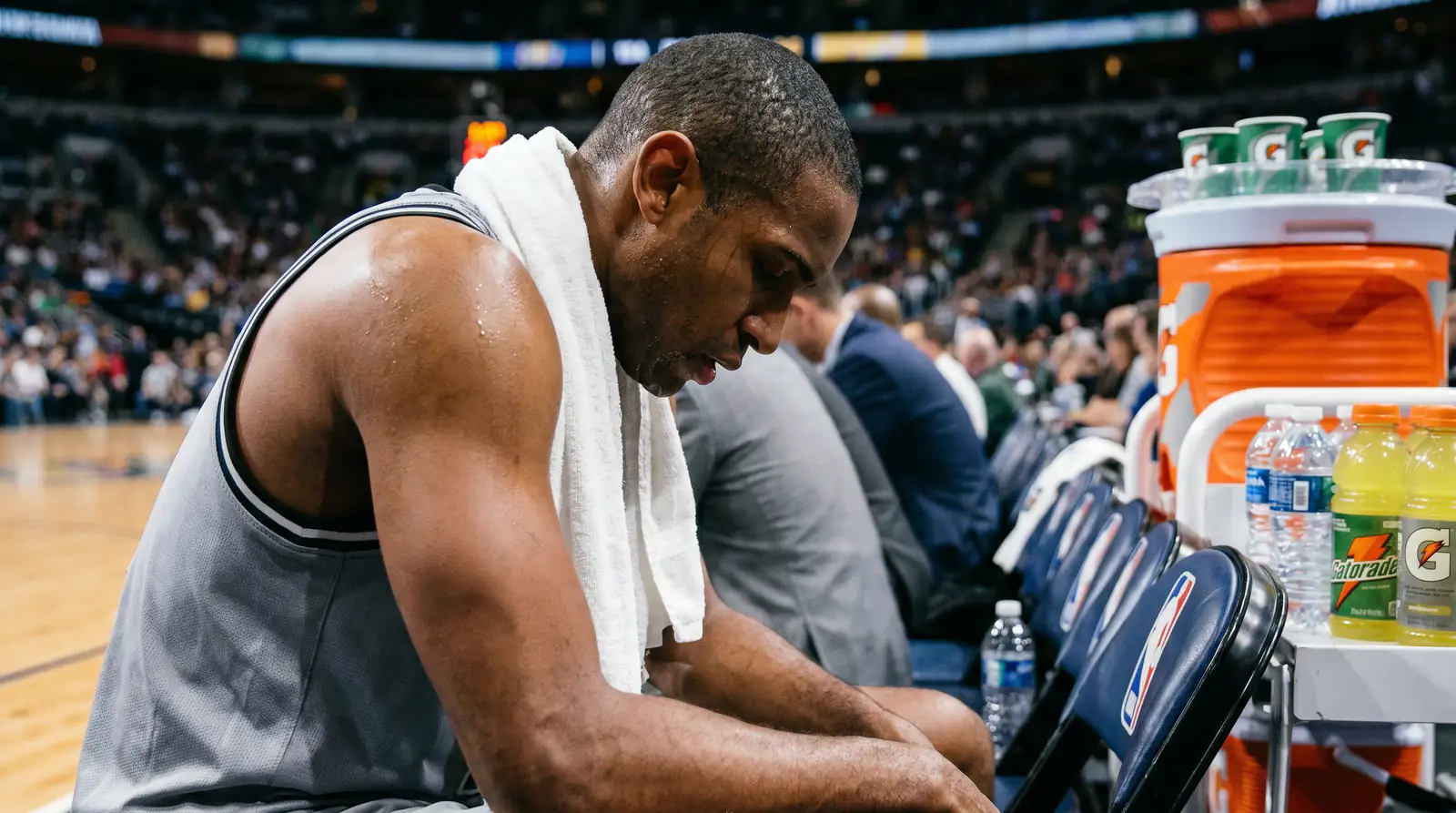 Giocatore NBA in panchina con espressione di stanchezza durante un timeout