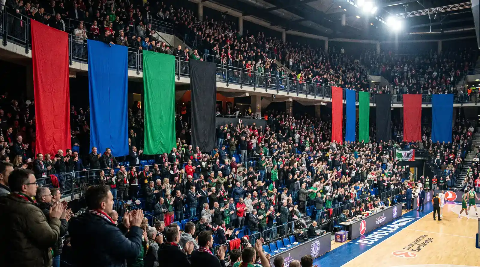 Striscioni dei club di Eurolega esposti lungo le tribune di un palazzetto durante una partita internazionale