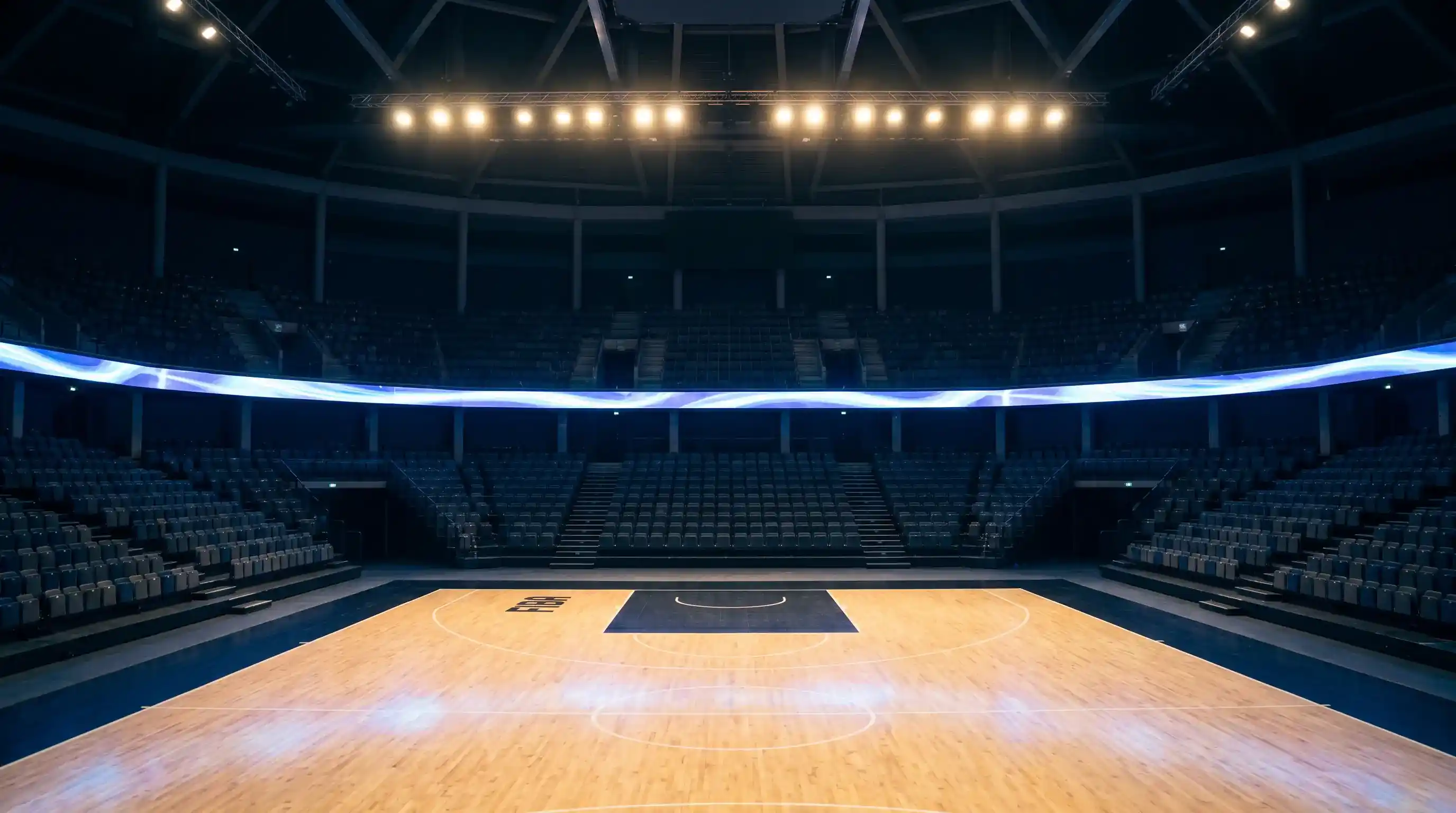 Interno di un'arena europea di pallacanestro con parquet lucido e tabellone luminoso sospeso