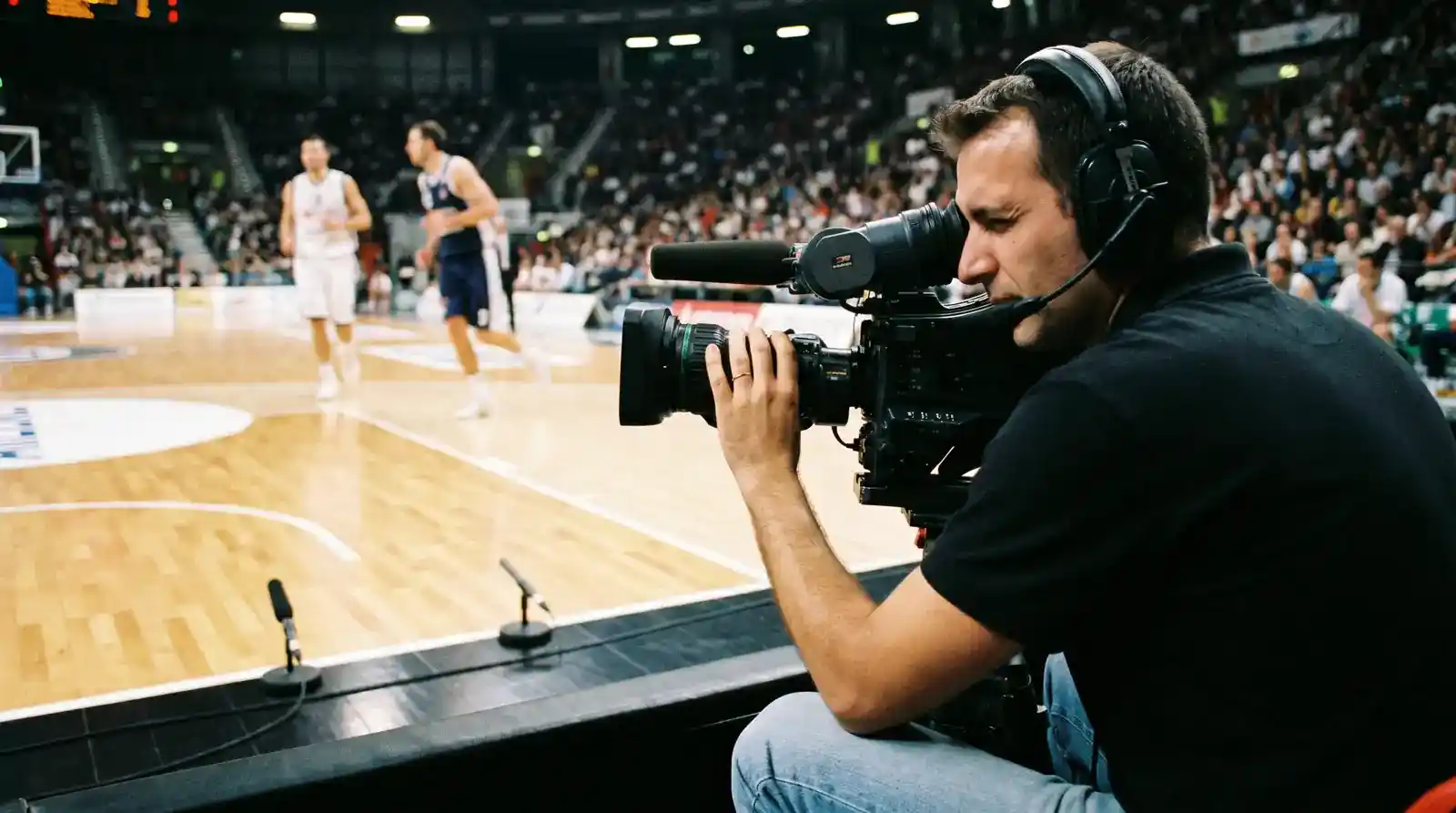 Cameraman a bordocampo riprende una partita di Serie A LBA da una postazione vicino alla linea laterale