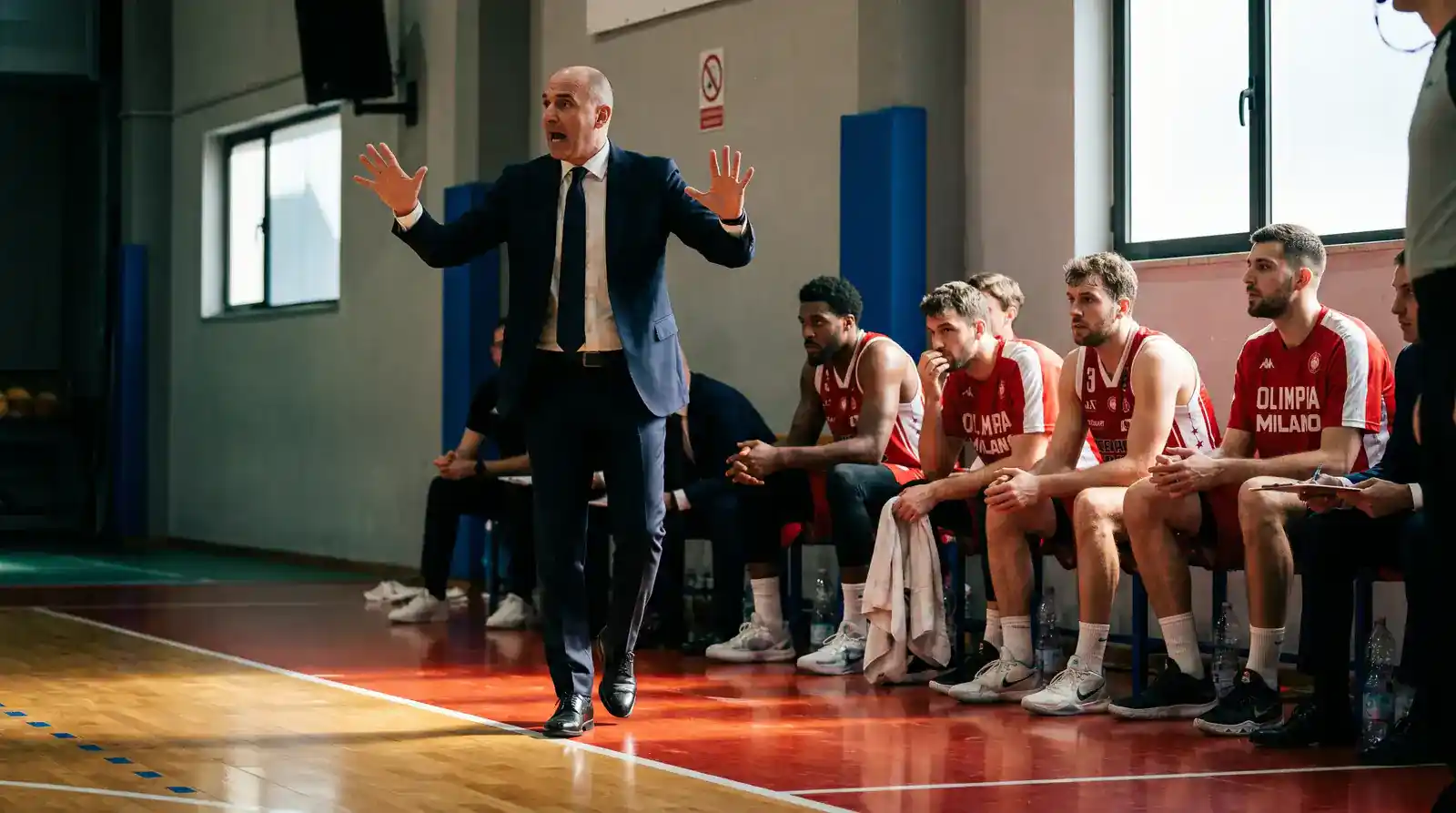 Coach Olimpia Milano impartisce istruzioni in panchina durante una partita di Serie A LBA