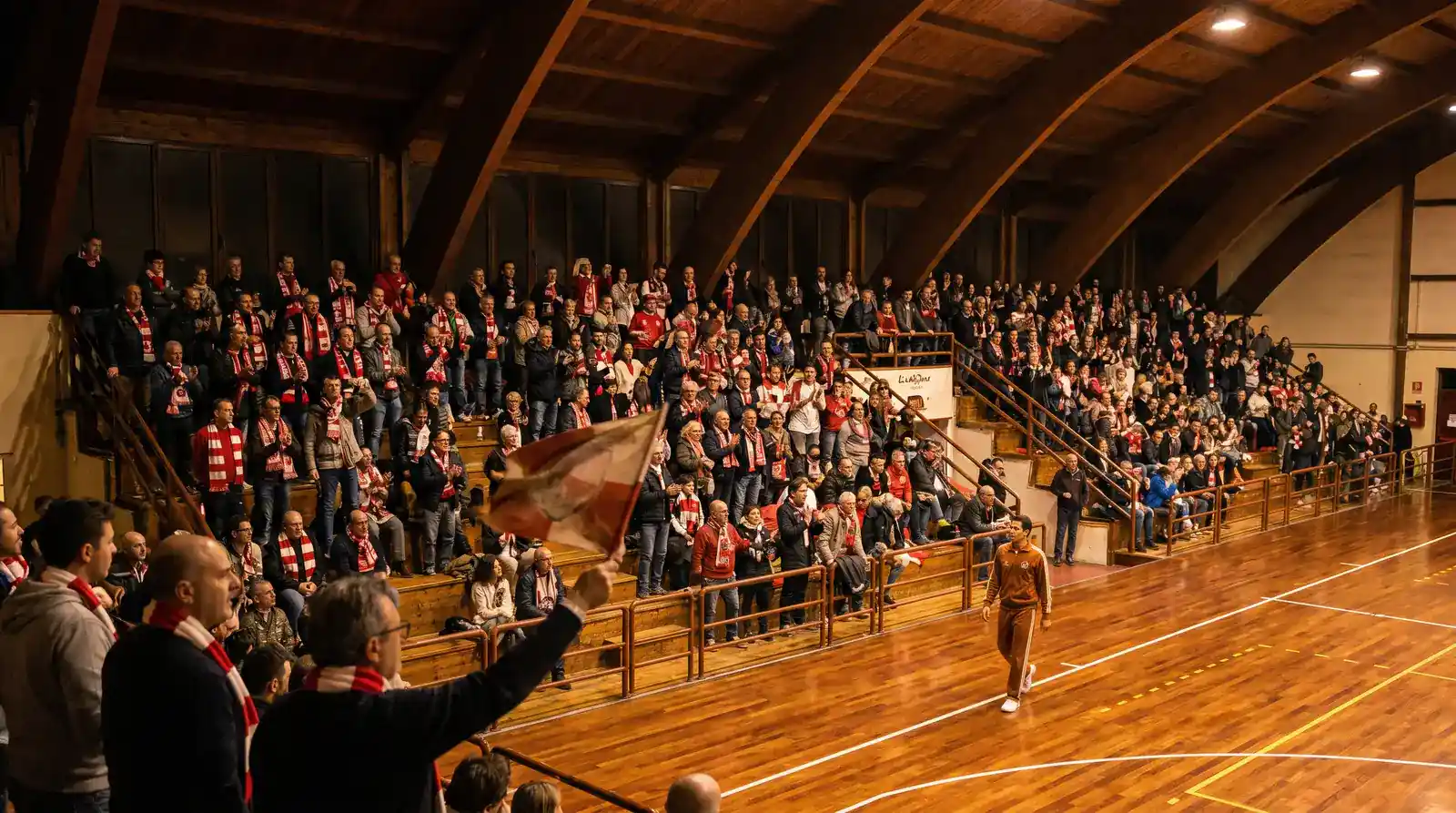Tribune ravvicinate al parquet di un palazzetto storico bolognese gremite di tifosi durante una partita di pallacanestro